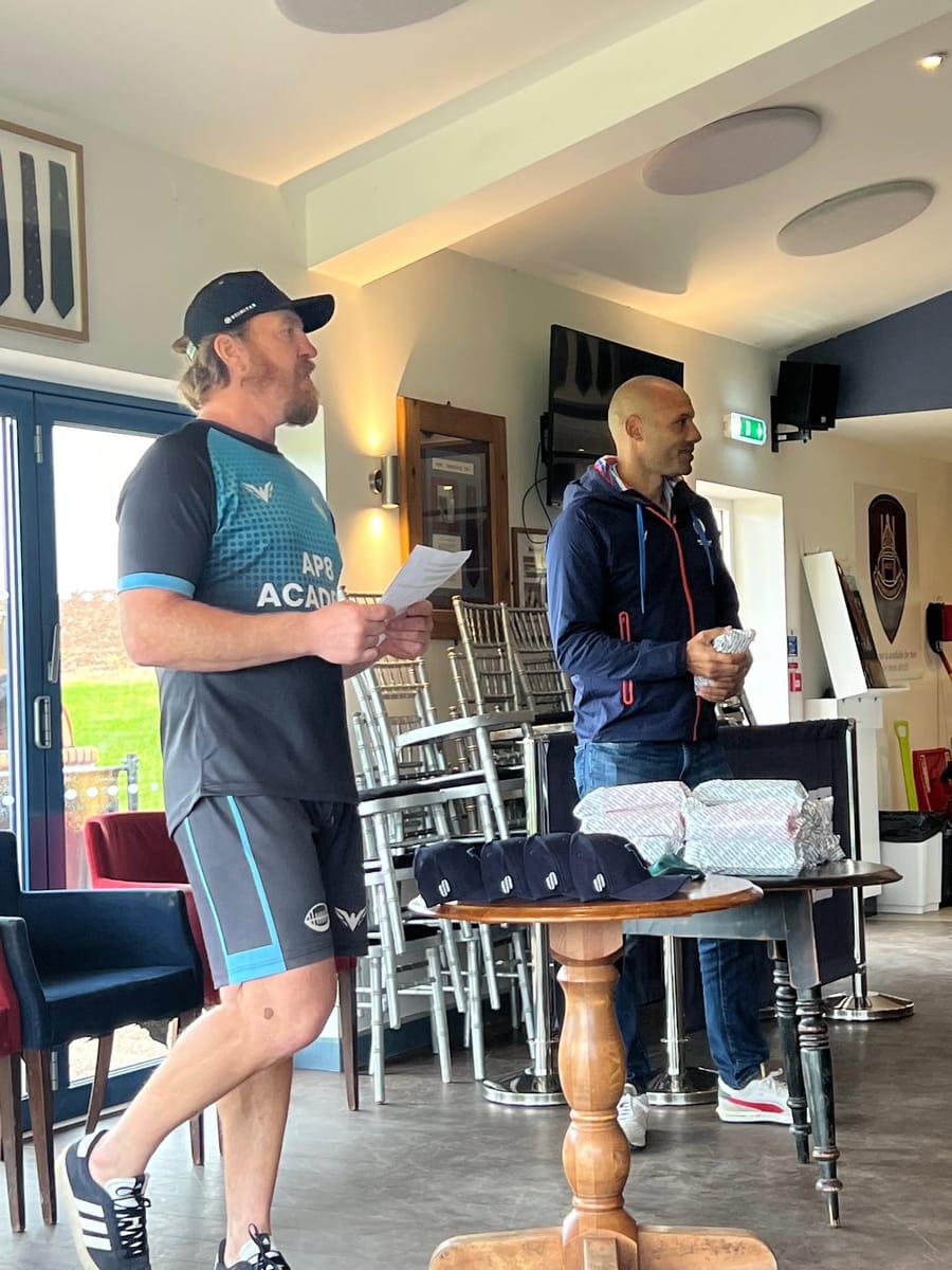 Andy Powell reading out the awards in the clubhouse, wrapped prizes and caps on the table